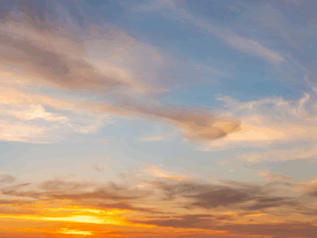 Ciel au coucher du soleil avec des nuages rosés et orangés, illuminés par la lumière douce du crépuscule.